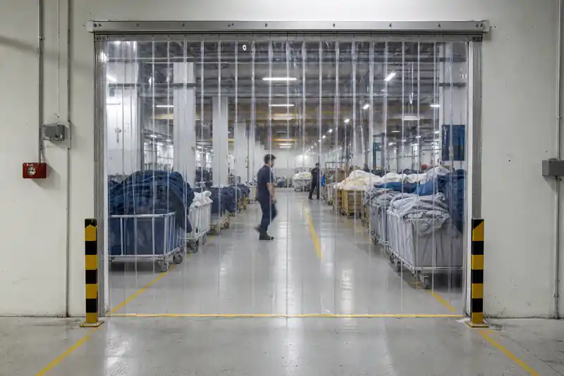 Crystal clear PVC strip doors improving visibility at a textile factory aisle crossing